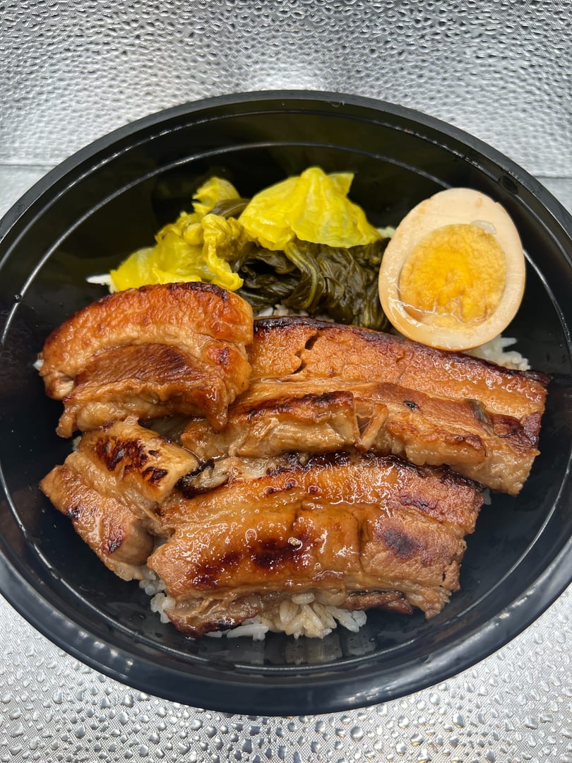 Braised pork belly over rice with pickled mustard greens and a soy-marinated egg.
